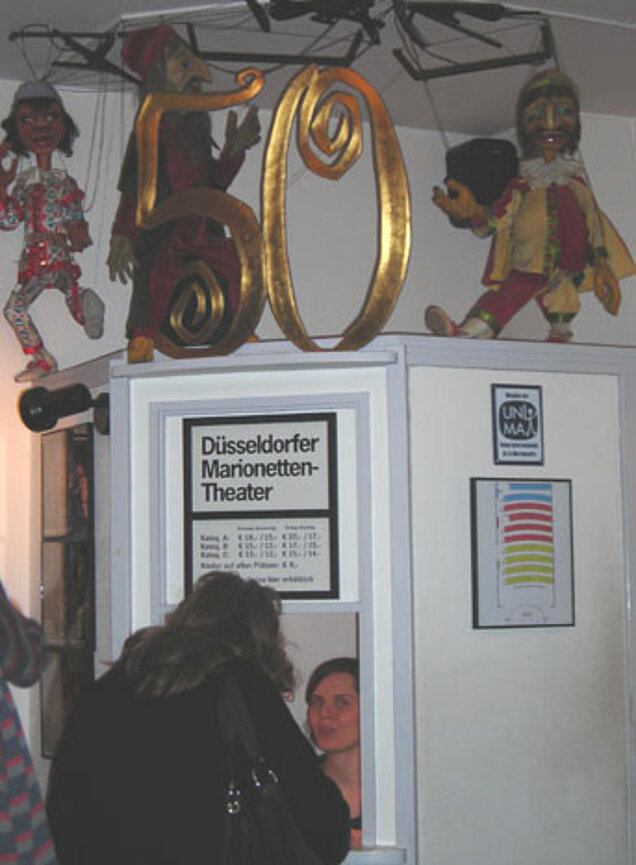 Eine Frau steht an der Theaterkasse.