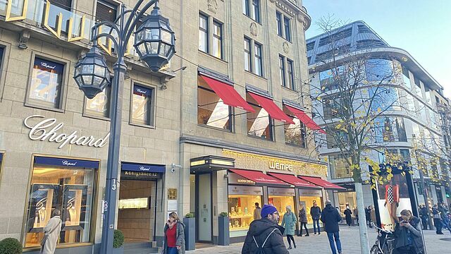 Menschen kaufen ein auf der Königsallee.