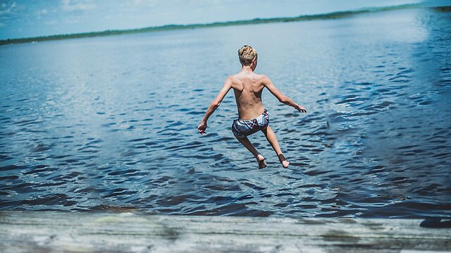 Mann springt ins Wasser