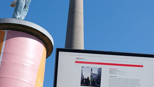 Laptop mit der d:kult Seite vor einer der Säulenheiligen