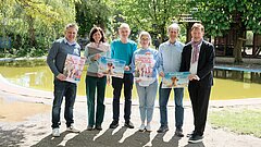 Menschen halten Plakate für die Bewerbung der Düsselfeiren 2024