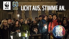 Menschen stehen nebeneinander vor dem Brandenburger Tor