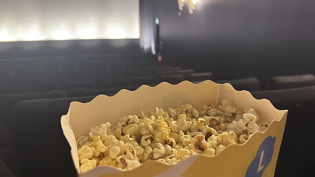 Popcorn vor einer Kinoleinwand
