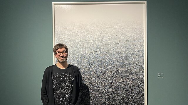 Der Fotograf Andreas Gefeller vor einem seiner Werke.