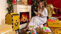 Das Christkind sitzt zwischen den Briefen der Kinder