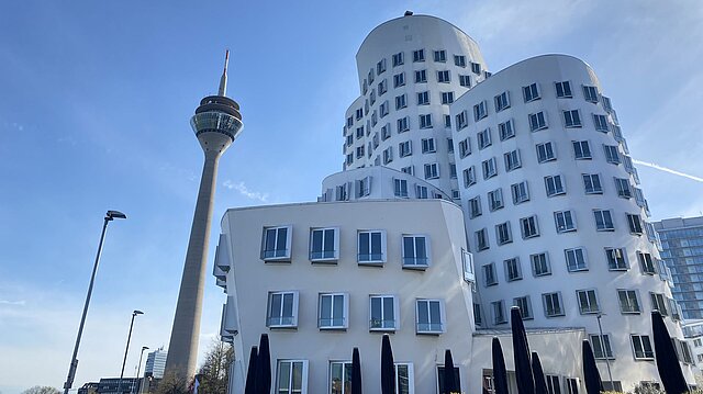Der Rheinturm neben den Frank Gehry Bauten