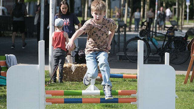 Junge springt über Hindernis
