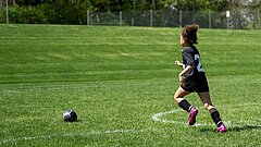 Mädchen läuft zum Fussball