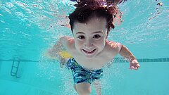 Kind taucht im Schwimmbecken