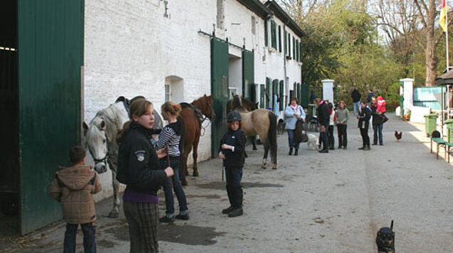 Kinder stehen bereit zum Reiten.