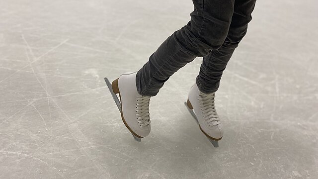 Schlittschuhe auf Eisfläche.